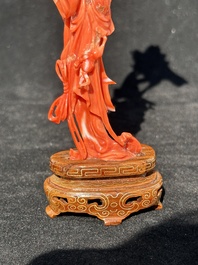 A Chinese red coral figure of a standing lady holding a flower, 19/20th C.