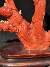 A Chinese carved red coral group with goddesses on wooden stand, 19/20th C.
