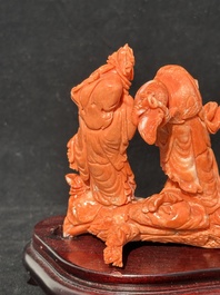 A Chinese red coral 'Sanxing' group on wooden stand, 19/20th C.