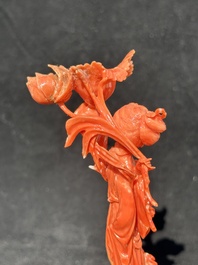 A Chinese red coral figure of a standing lady holding a flower, 19/20th C.