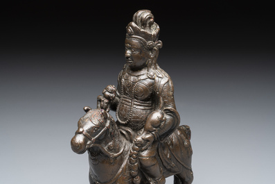 A rare Chinese bronze Vaishravana on horseback with wooden stand, Yuan