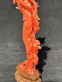 A Chinese red coral figure of a standing lady holding a flower, 19/20th C.