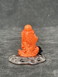 A Chinese carved red coral 'dragon' snuff bottle on wooden stand, 19/20th C.