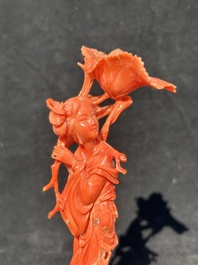 A Chinese red coral figure of a standing lady holding a flower, 19/20th C.