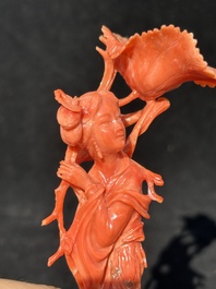A Chinese red coral figure of a standing lady holding a flower, 19/20th C.