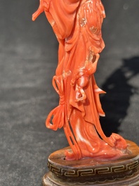 A Chinese red coral figure of a standing lady holding a flower, 19/20th C.