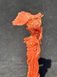 A Chinese red coral figure of a standing lady holding a flower, 19/20th C.
