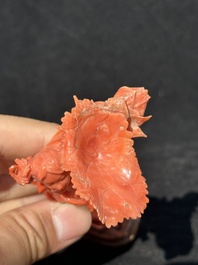A Chinese red coral figure of a standing lady holding a flower, 19/20th C.