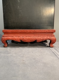 A Chinese cinnabar lacquer 'mountainous landscape' cabinet on a stand, 19th C.