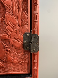 A Chinese cinnabar lacquer 'mountainous landscape' cabinet on a stand, 19th C.