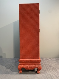 A Chinese cinnabar lacquer 'mountainous landscape' cabinet on a stand, 19th C.