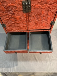 A Chinese cinnabar lacquer 'mountainous landscape' cabinet on a stand, 19th C.