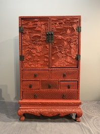 A Chinese cinnabar lacquer 'mountainous landscape' cabinet on a stand, 19th C.