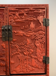 A Chinese cinnabar lacquer 'mountainous landscape' cabinet on a stand, 19th C.