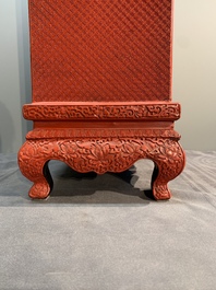 A Chinese cinnabar lacquer 'mountainous landscape' cabinet on a stand, 19th C.
