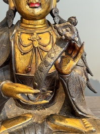 An impressive and large Chinese partially lacquered and gilt bronze Guanyin on a lotus throne, Ming