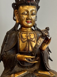 An impressive and large Chinese partially lacquered and gilt bronze Guanyin on a lotus throne, Ming