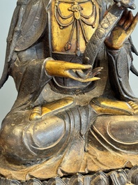 An impressive and large Chinese partially lacquered and gilt bronze Guanyin on a lotus throne, Ming