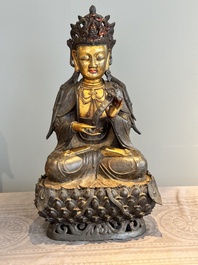An impressive and large Chinese partially lacquered and gilt bronze Guanyin on a lotus throne, Ming