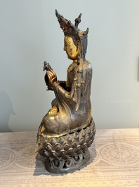 An impressive and large Chinese partially lacquered and gilt bronze Guanyin on a lotus throne, Ming