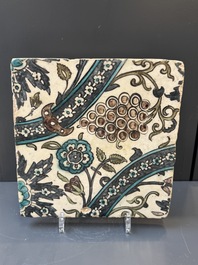 A Syrian Damascus Iznik-style tile with grape and flower scrolls, early 17th C.
