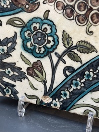 A Syrian Damascus Iznik-style tile with grape and flower scrolls, early 17th C.