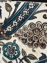A Syrian Damascus Iznik-style tile with grape and flower scrolls, early 17th C.