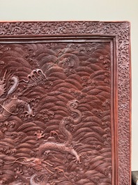 A rectangular Chinese carved red lacquer 'dragon' table screen, later wooden stand, Qianlong