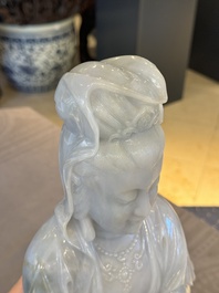 An exceptional and large Chinese carved pale lavender jadeite Guanyin on a wooden stand, Republic