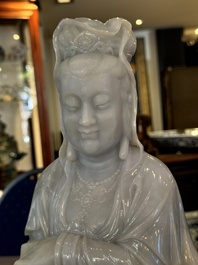 An exceptional and large Chinese carved pale lavender jadeite Guanyin on a wooden stand, Republic
