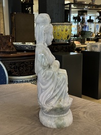 An exceptional and large Chinese carved pale lavender jadeite Guanyin on a wooden stand, Republic
