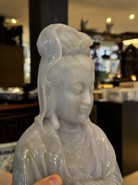 An exceptional and large Chinese carved pale lavender jadeite Guanyin on a wooden stand, Republic