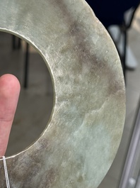 A Chinese celadon and russet jade 'bi' disc, Neolithic period