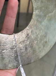 A Chinese celadon and russet jade 'bi' disc, Neolithic period