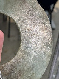 A Chinese celadon and russet jade 'bi' disc, Neolithic period