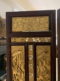 A Chinese four-part reticulated and partially gilt wooden folding screen, 19th C.