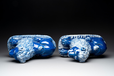 A pair of white-decorated blue-ground faience models of reclining lions, Nevers, 18th C.