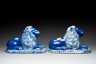A pair of white-decorated blue-ground faience models of reclining lions, Nevers, 18th C.