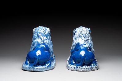 A pair of white-decorated blue-ground faience models of reclining lions, Nevers, 18th C.