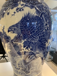 A massive Japanese blue and white Arita vase and cover with an eagle, a shishi and cub, 19th C.