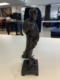 A fine Chinese bronze Luohan holding a sutra, Ming