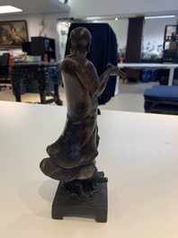 A fine Chinese bronze Luohan holding a sutra, Ming