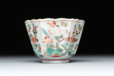 A fine Chinese famille verte 'boy and lotus' flower-shaped cup and a wooden stand, Kangxi