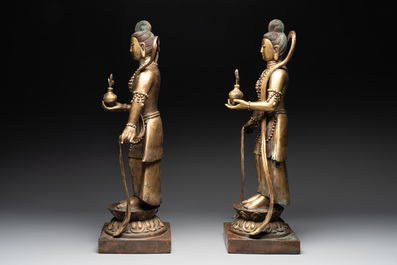 A pair of large Chinese gilt bronze offering figures on stand, 19th C.