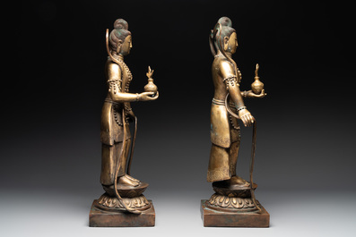A pair of large Chinese gilt bronze offering figures on stand, 19th C.
