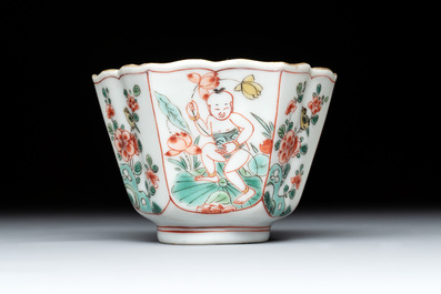A fine Chinese famille verte 'boy and lotus' flower-shaped cup and a wooden stand, Kangxi