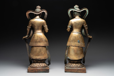 A pair of large Chinese gilt bronze offering figures on stand, 19th C.