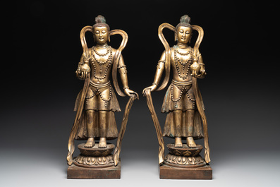 A pair of large Chinese gilt bronze offering figures on stand, 19th C.