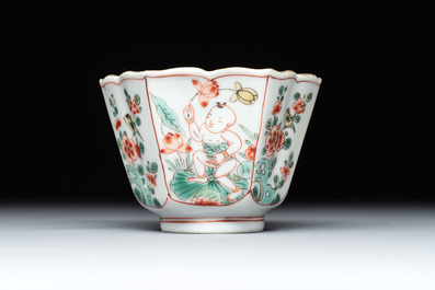 A fine Chinese famille verte 'boy and lotus' flower-shaped cup and a wooden stand, Kangxi
