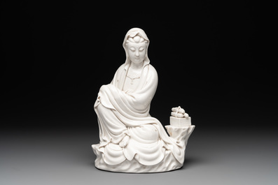 A Chinese Dehua blanc de Chine figure of a seated Guanyin on wooden stand, 19/20th C.